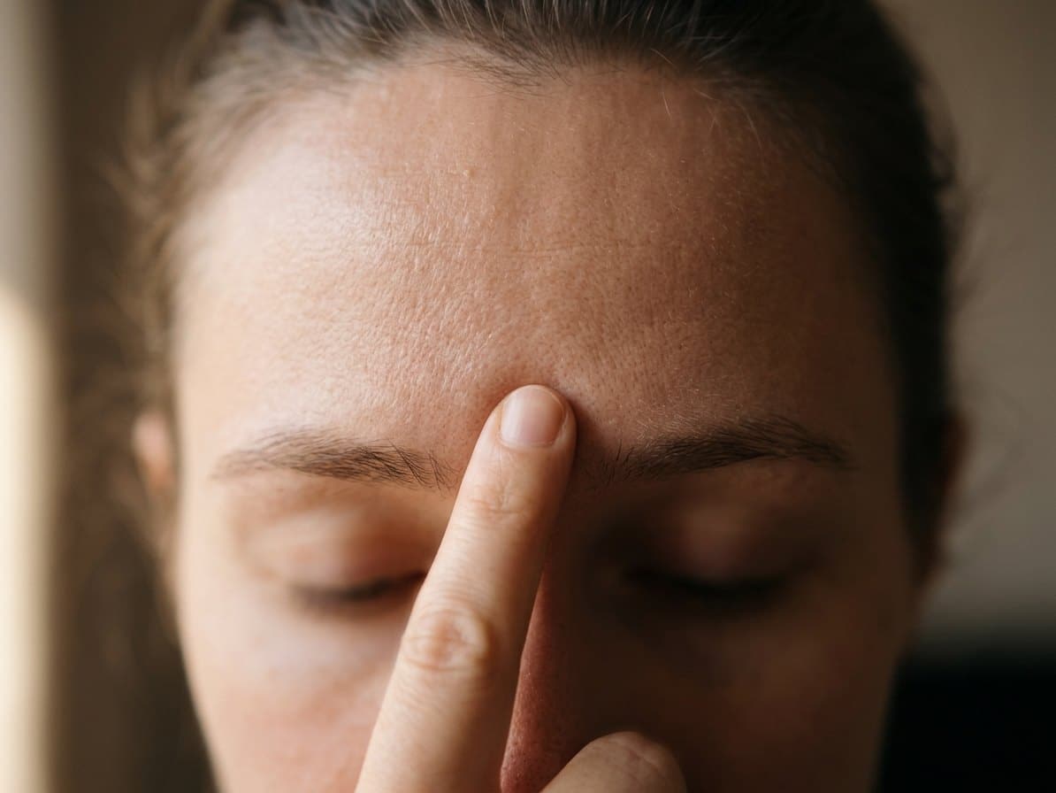 Doigt posé doucement entre les sourcils sur le point du troisième oeil